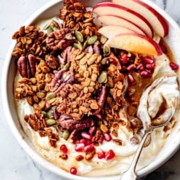 pumpkin spice granola in a bowl with yogurt, nut butter, and fruit
