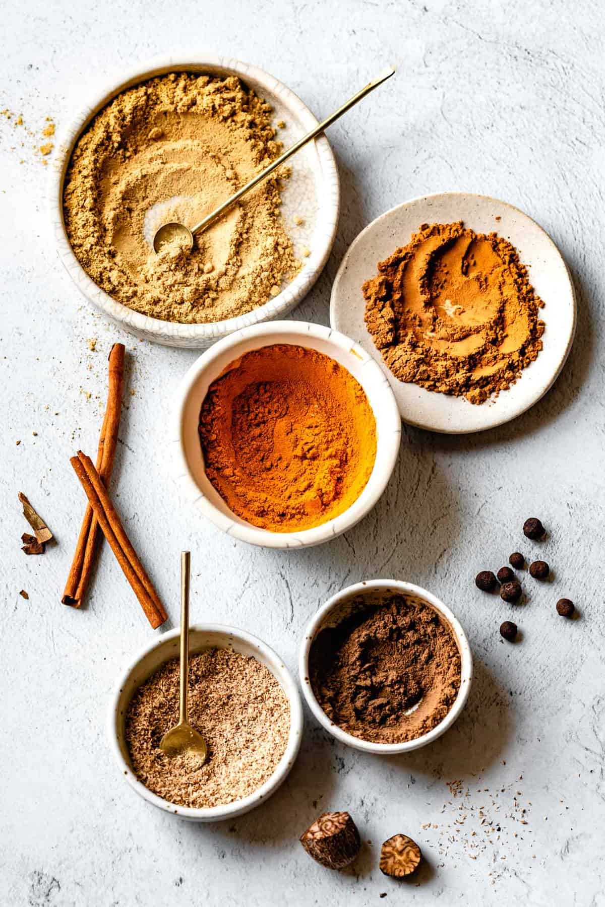 ground spices in small bowls for pumpkin spice seasoning