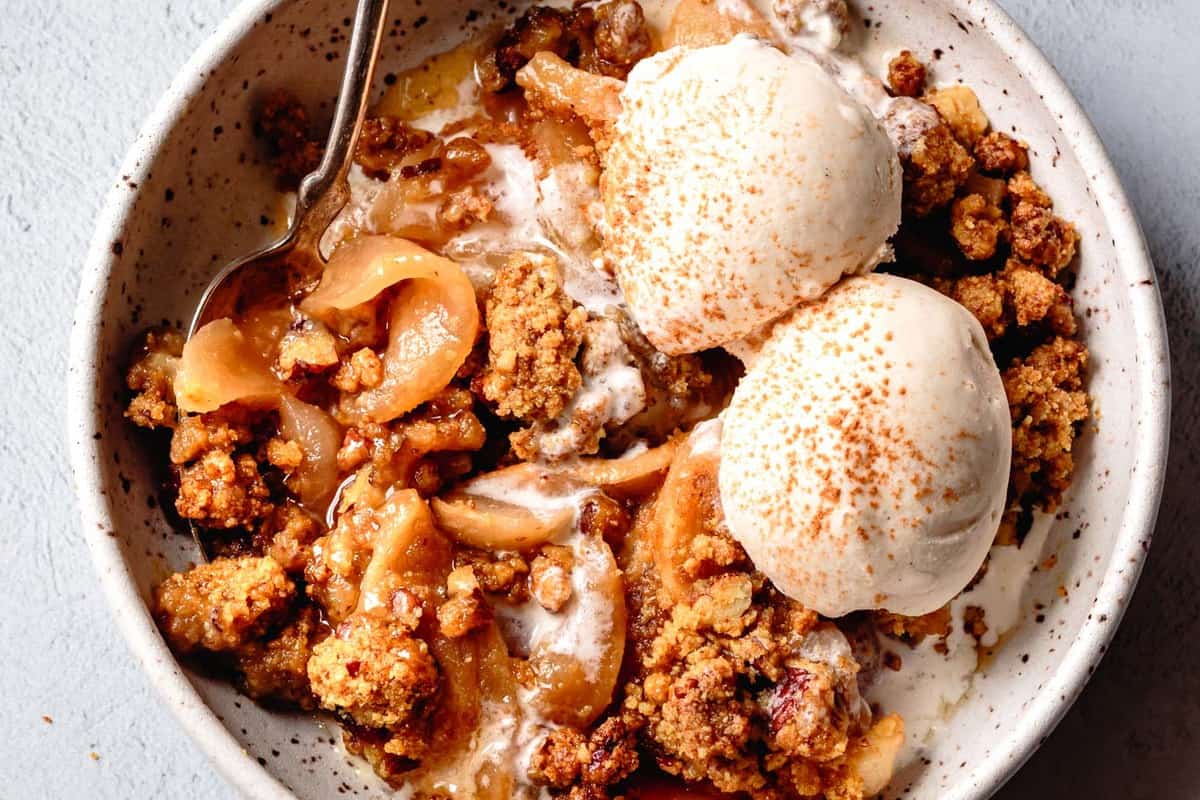 close-up overhead of paleo apple crumble in a bowl with ice cream