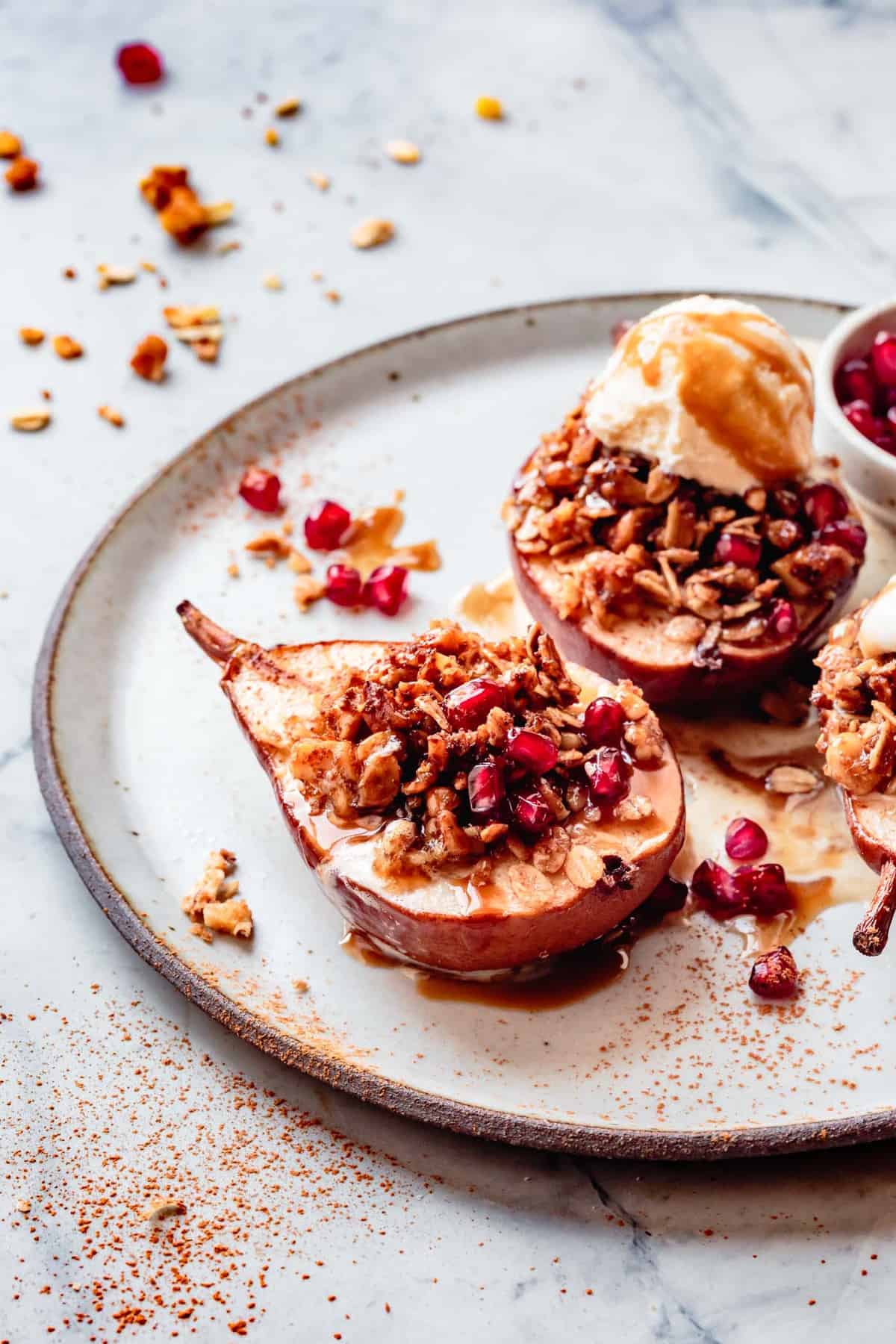 baked pears on a plate drizzled with butterscotch sauce and topped with ice cream