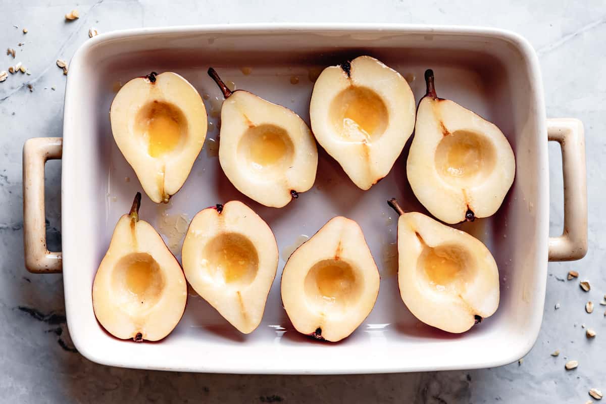 prepared pears brushed with melted butter in a roasting pan