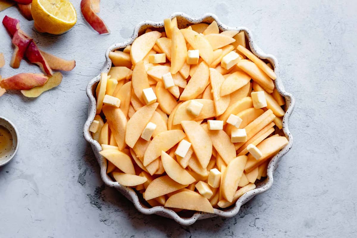 prepared apples in a pan dotted with butter