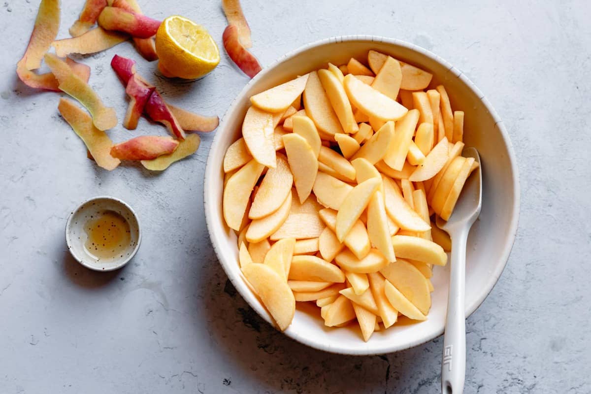 sliced apples in a bowl with maple syrup