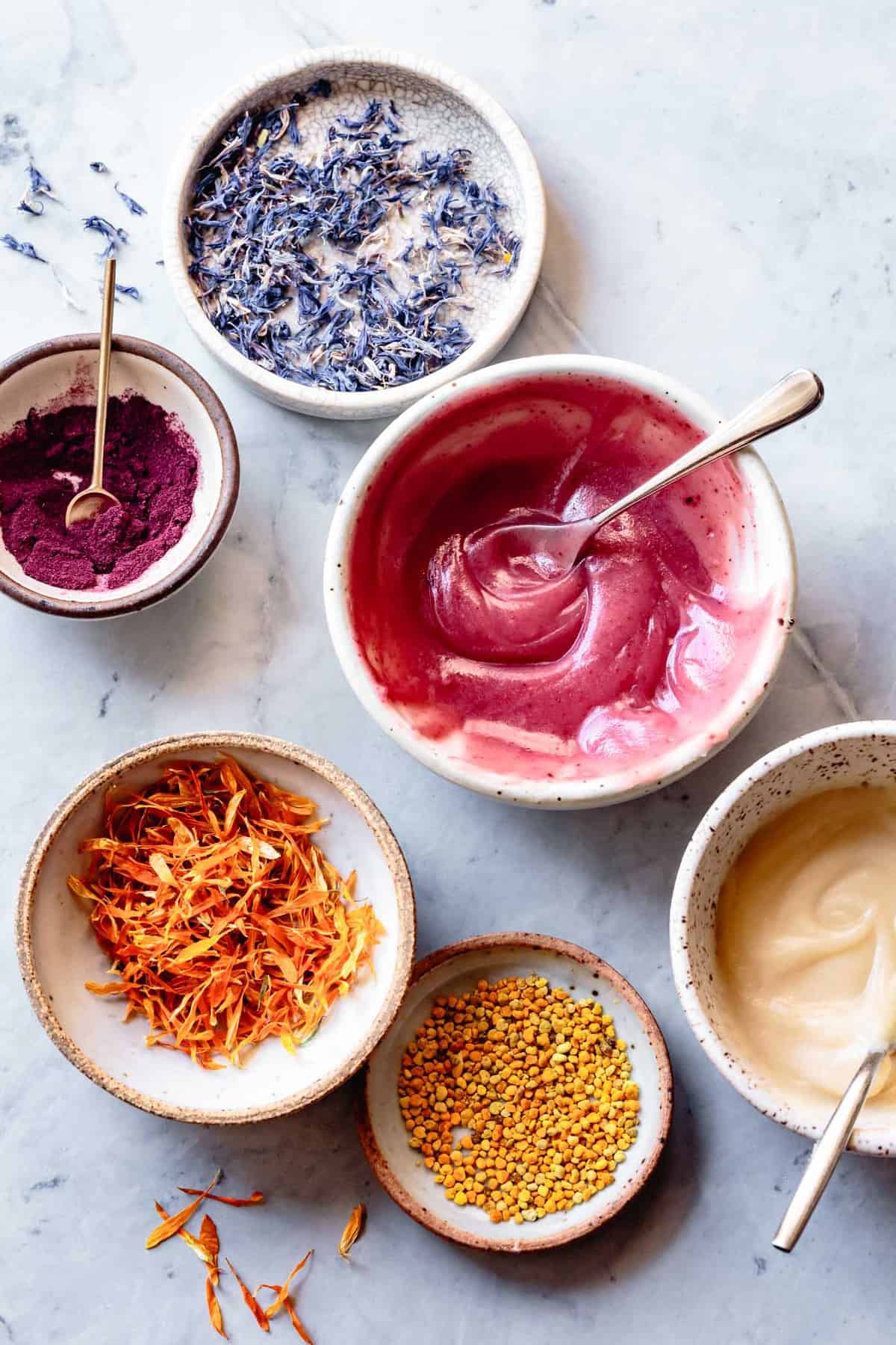 natural toppings for healthy sugar cookies: flower petals, pink icing, bee pollen in pretty little mismatched bowls