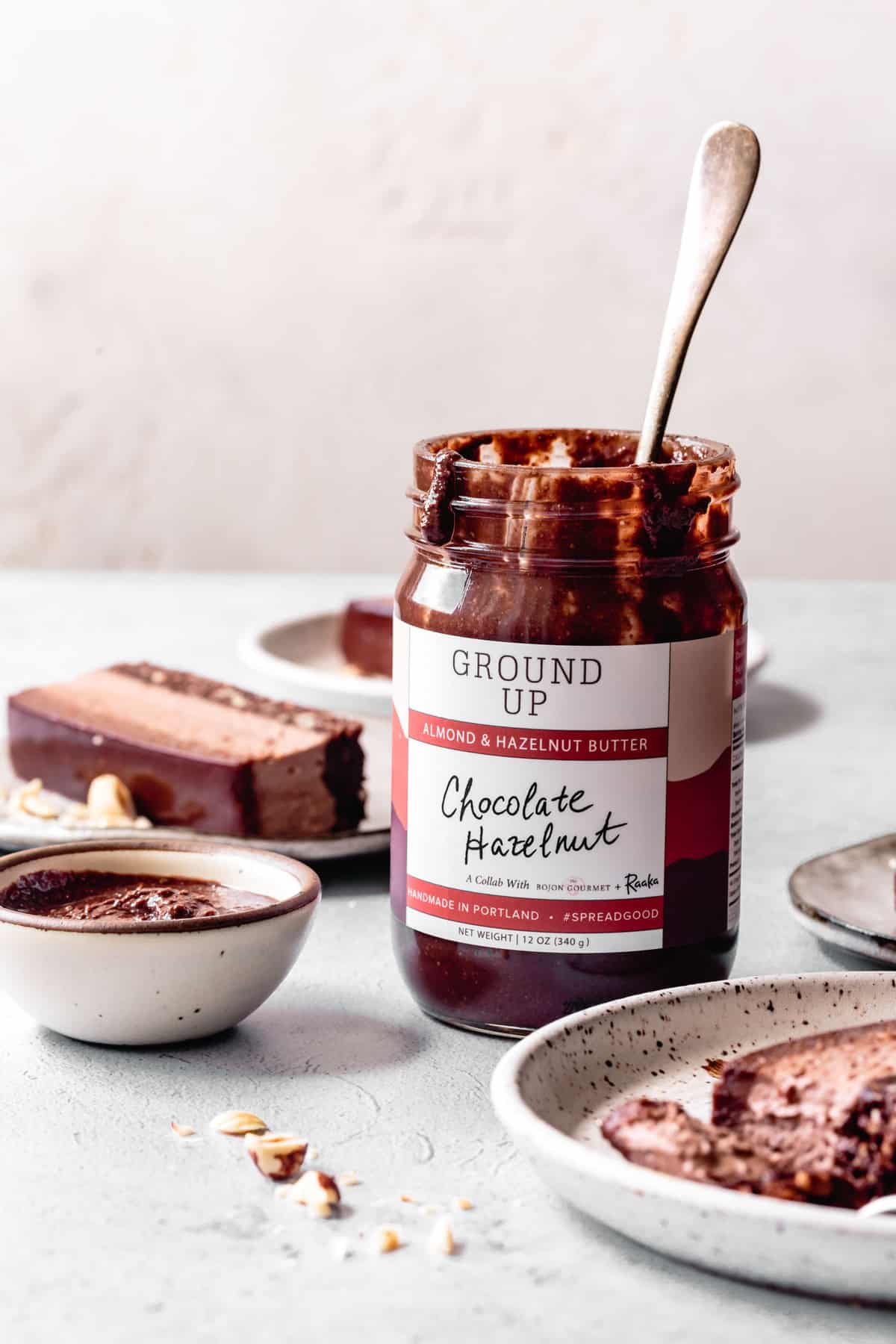 jar of chocolate hazelnut spread with a spoon in it and desserts around