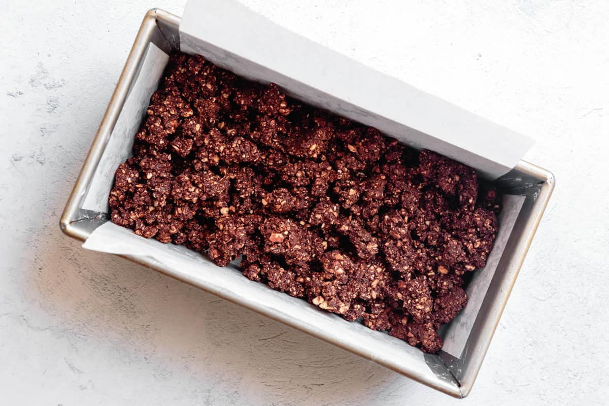 crumbles of cocoa nut crust in a loaf pan