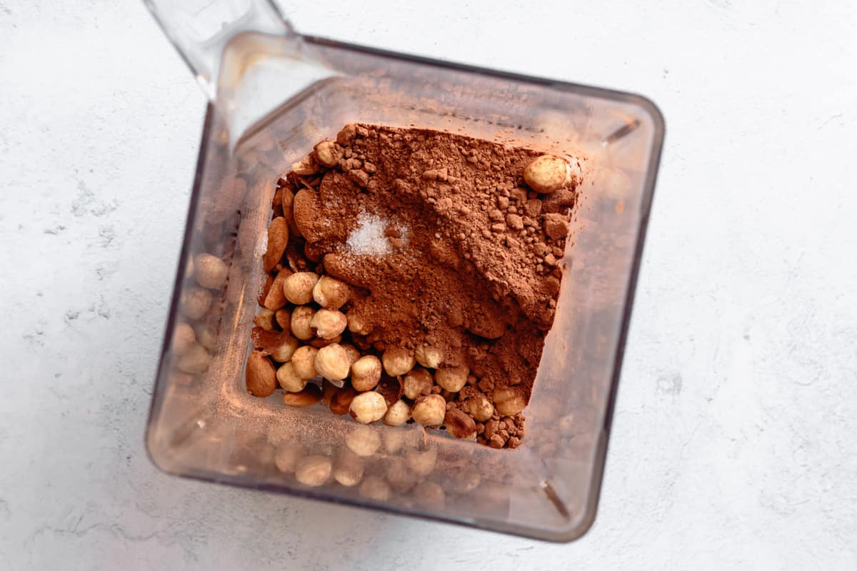 nuts and cocoa in a blender for cheesecake crust