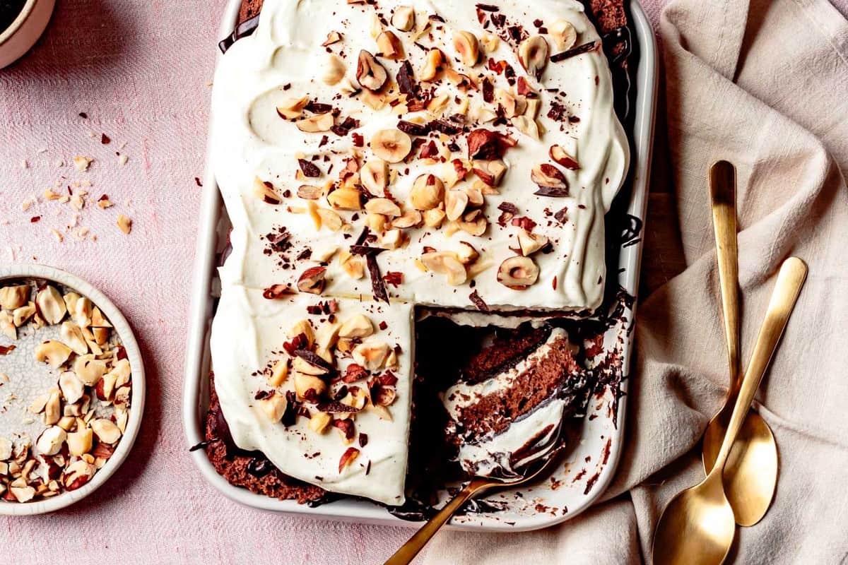 overhead of tiramisu with gold spoons and a slice cut out