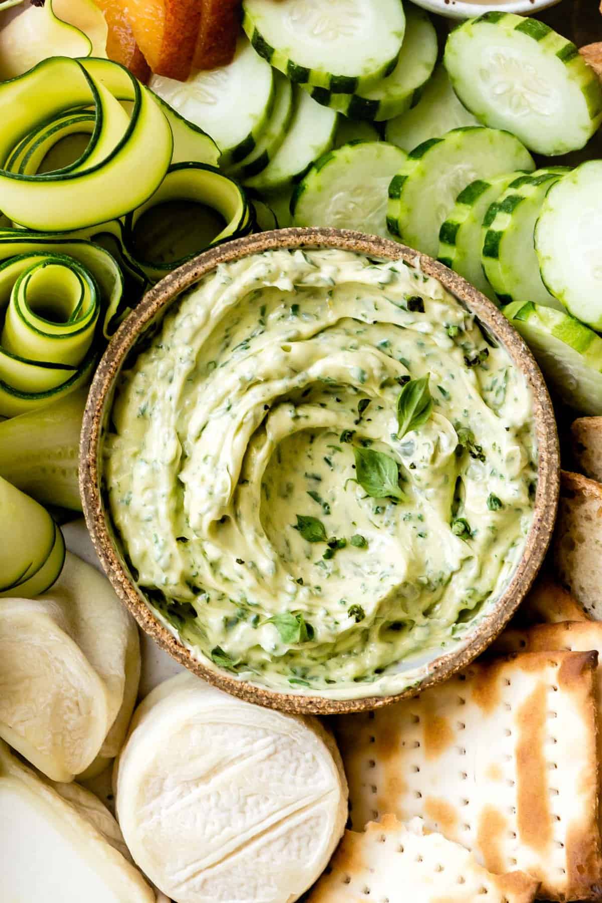 closeup shot of a bowl of basil butter with a pretty swirl and tiny adorable basil leaves on top