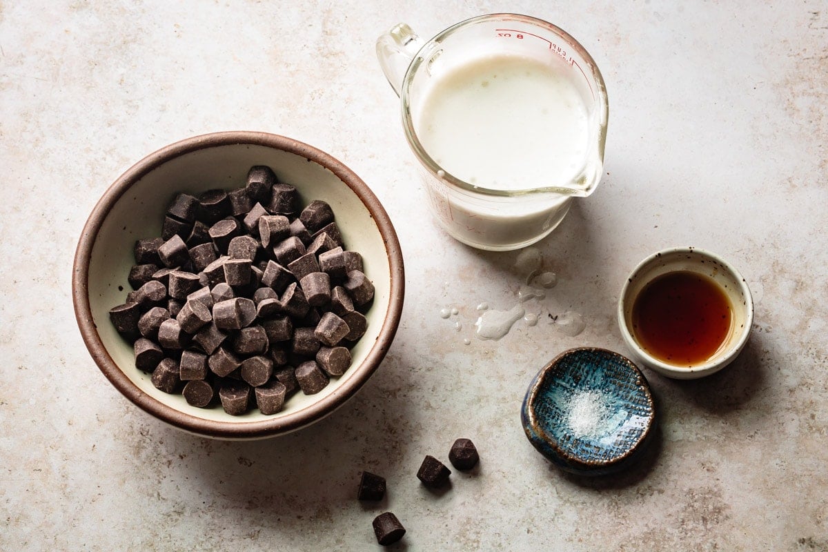 ingredients arranged in cute bowls: chocolate chunks, salt, vanilla, and coconut milk