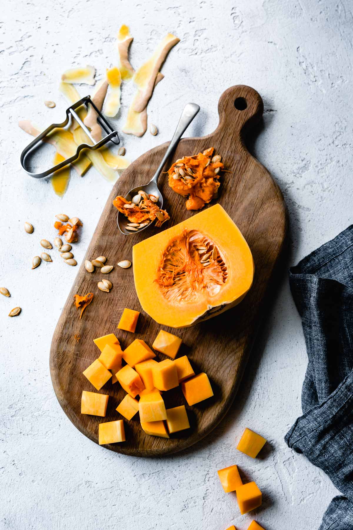 a butternut squash is in the process of being butchered on a wood board