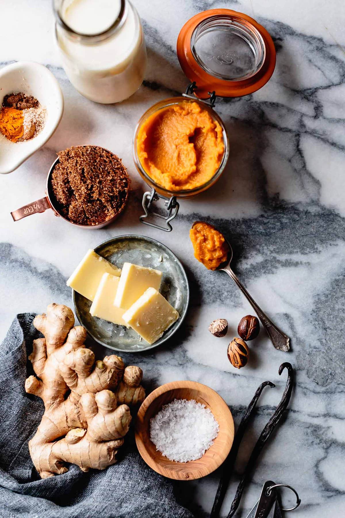 Ingredients for healthy pumpkin pudding have been arranged prettily on a marble countertop