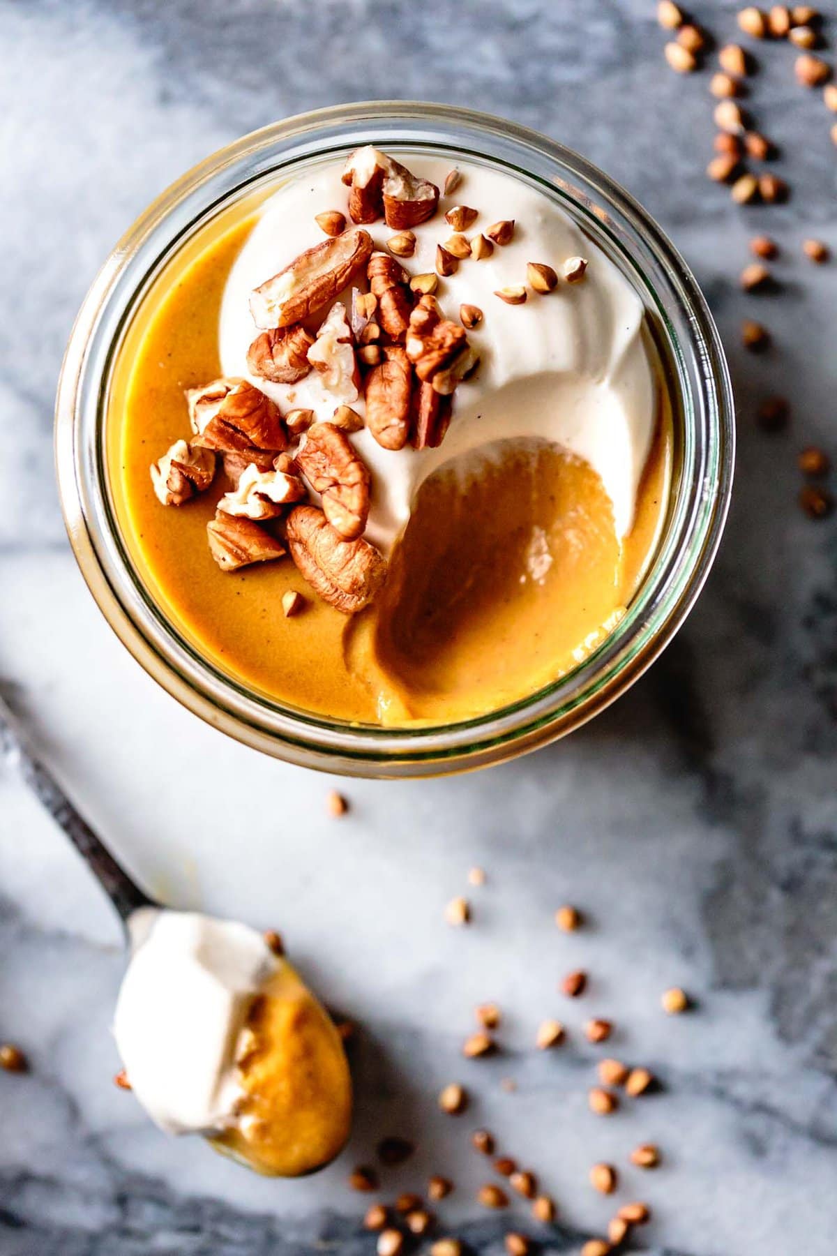 A sexy closeup shot of pumpkin pudding in a jar with a bite taken out revealing its creamy, luscious texture. Yorm!