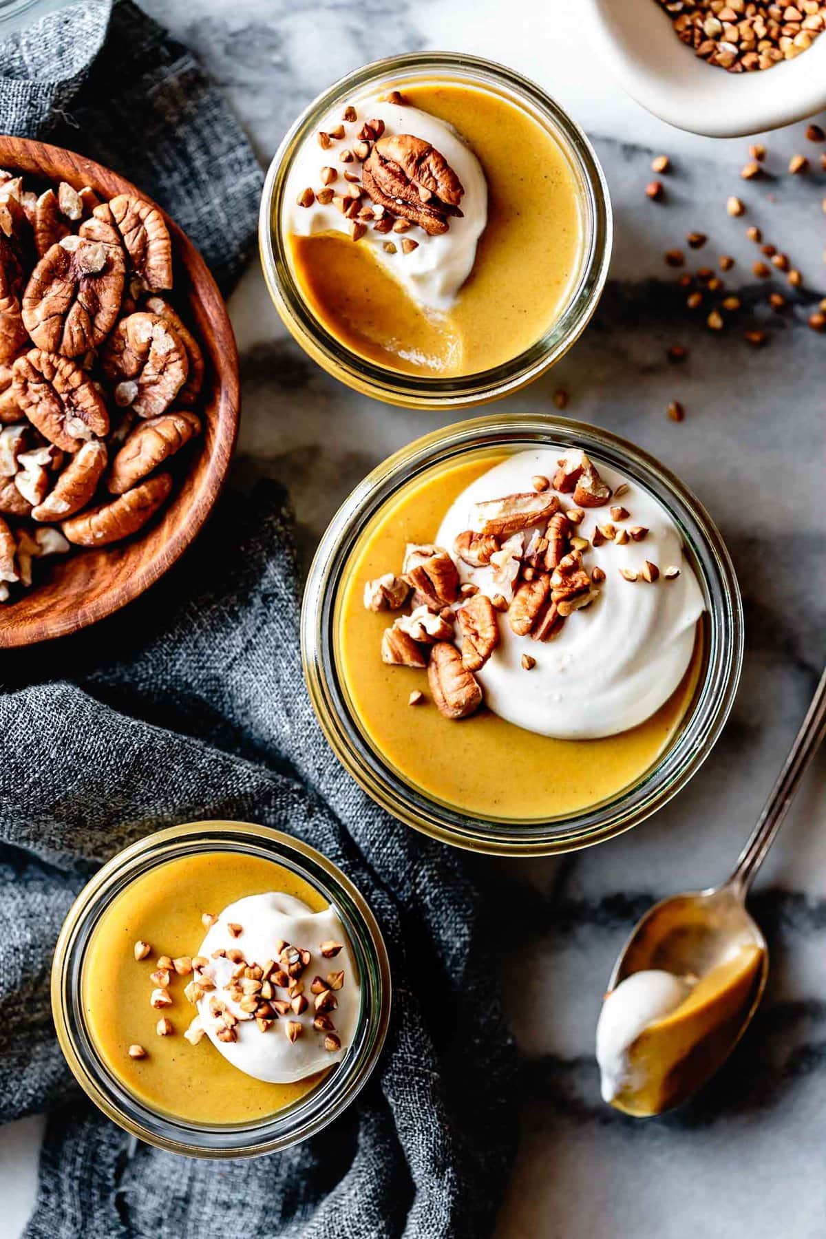 Pumpkin pie pudding in cute little jars on a marble surface