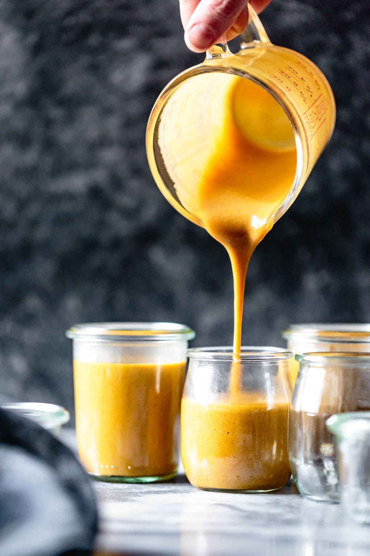 luscious golden pumpkin pudding is being poured into jars