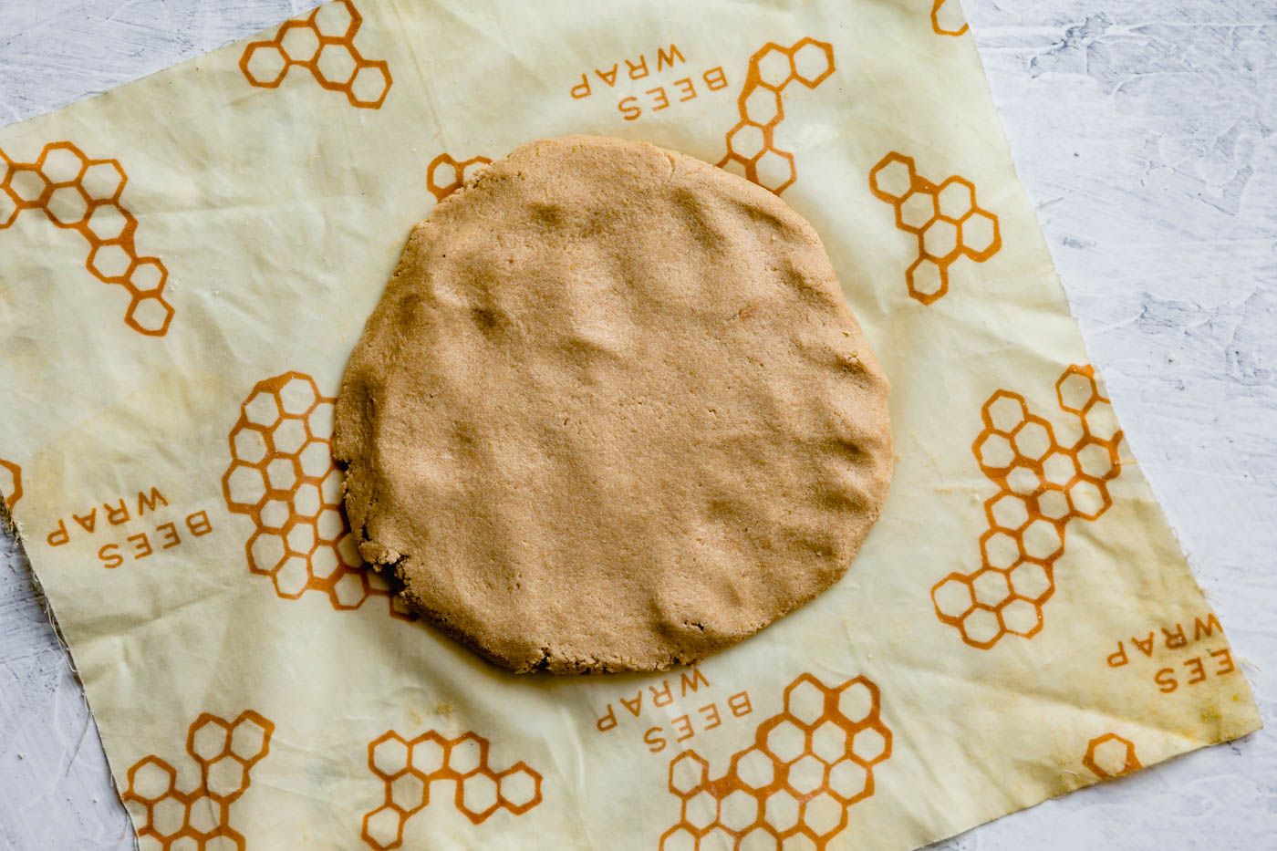 the finished dough has been shaped into a disk on a piece of beewax wrap