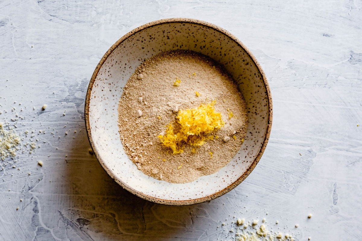 a speckled bowl has maple sugar and lemon zest in it