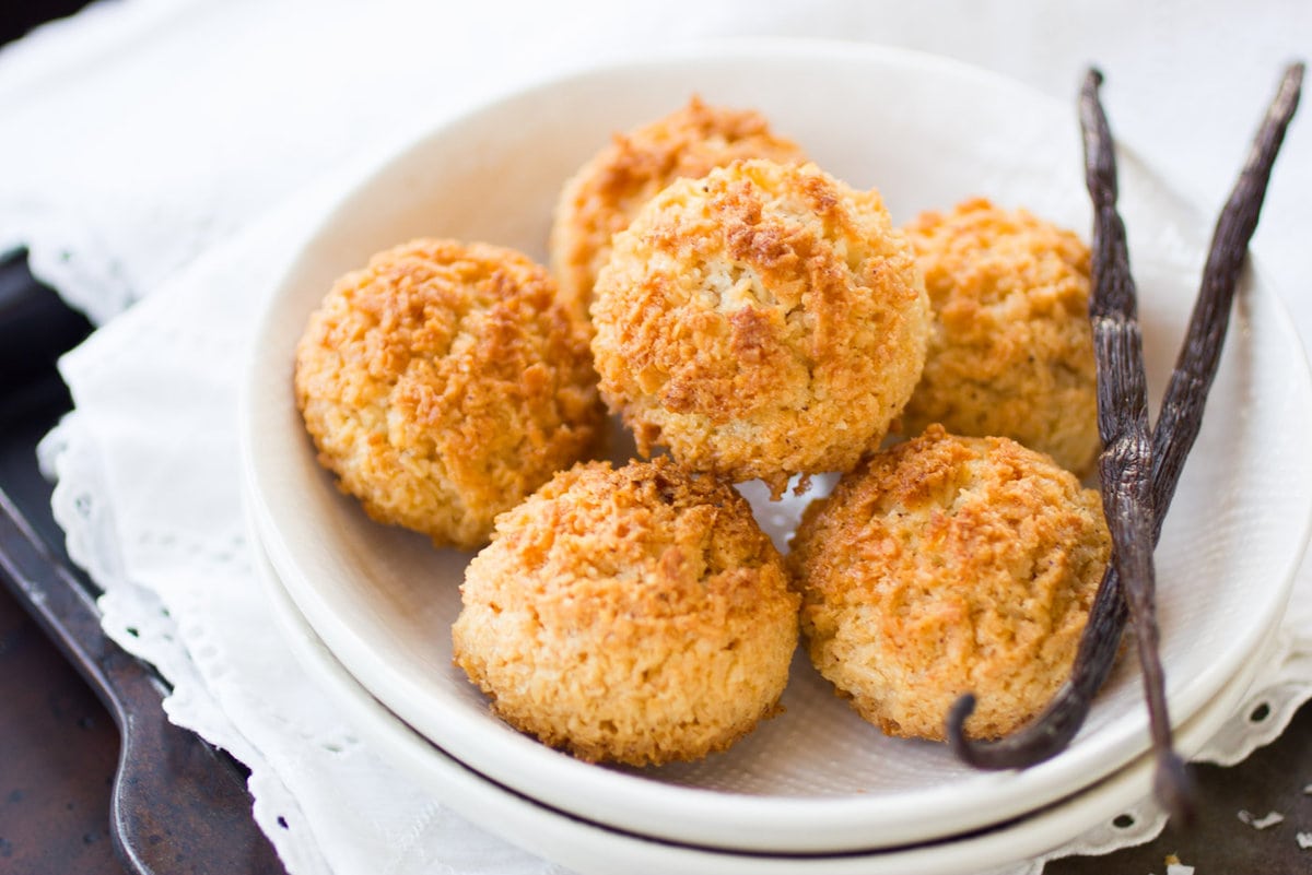 Golden, crispy coconut macaroons are piled onto a plate