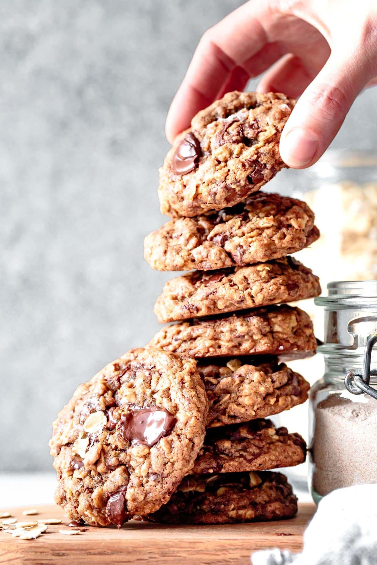 a hand is grabbing the top teff flour cookie from a stack of cookies made with gluten-free flours