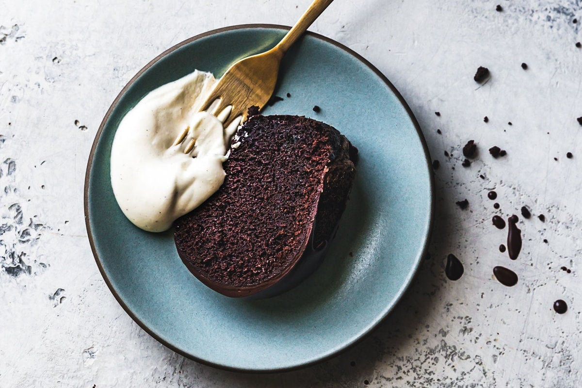 whipped creme fraiche has been dolloped over a slice of chocolate cake