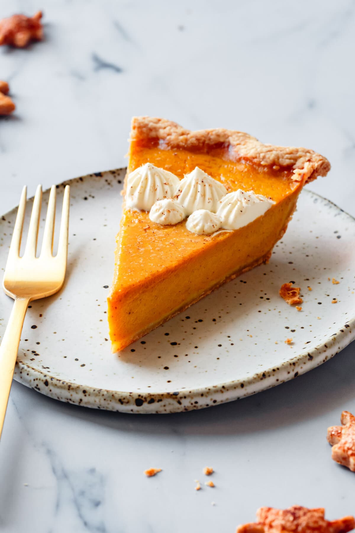 closeup photo of a slice of pie revealing golden, flaky crust and a super smooth orange filling