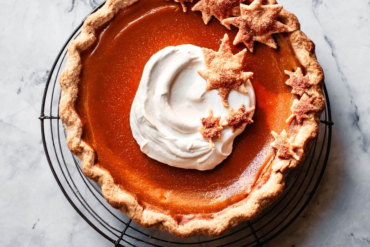 the finished pie has been topped with whipped cream and leaf cut-outs