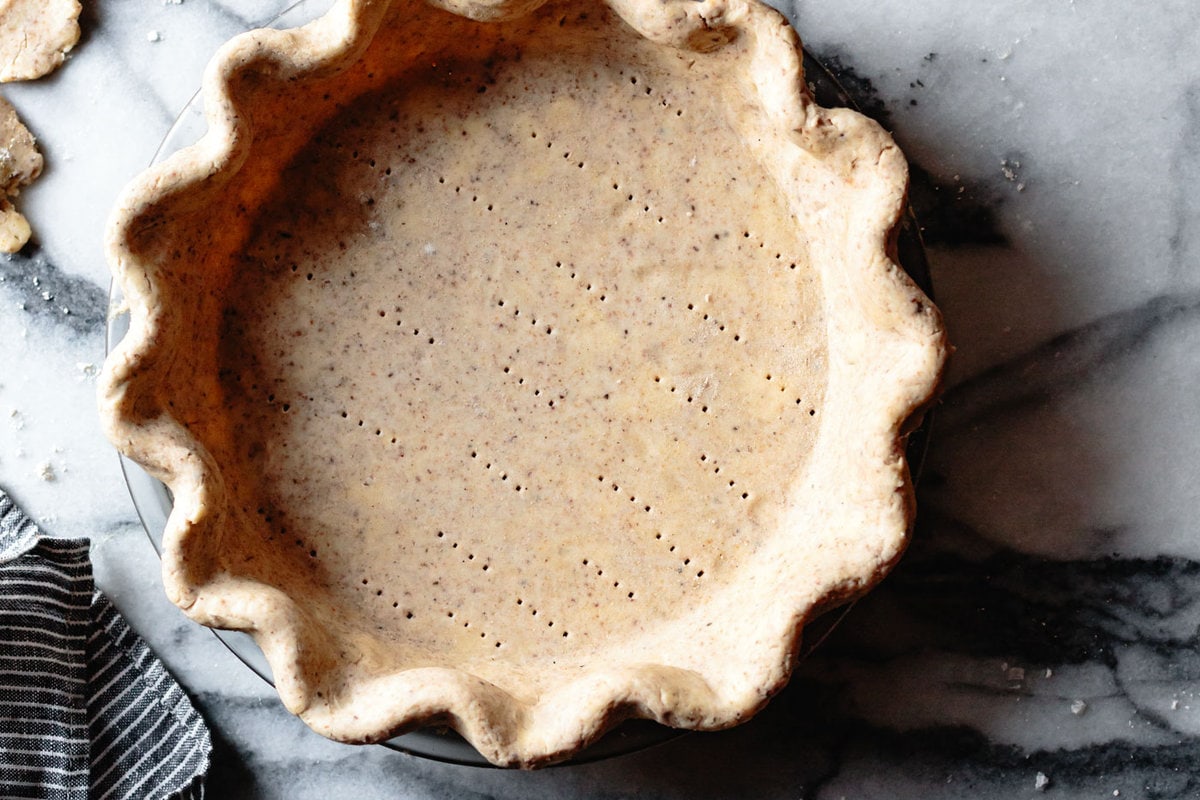 an unbaked gluten-free pie shell is on a marble countertop