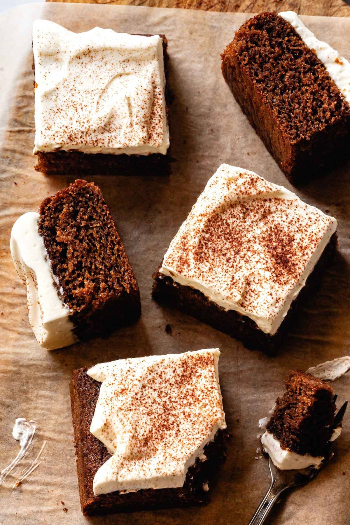 slices of gluten-free gingerbread cake have been placed haphazardly on a wooden serving board