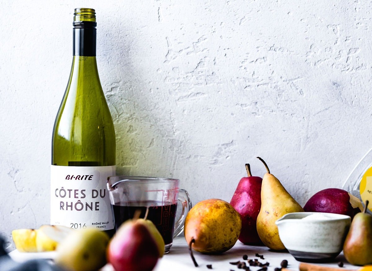 pear poaching ingredients are casually arranged on a textured kitchen counter