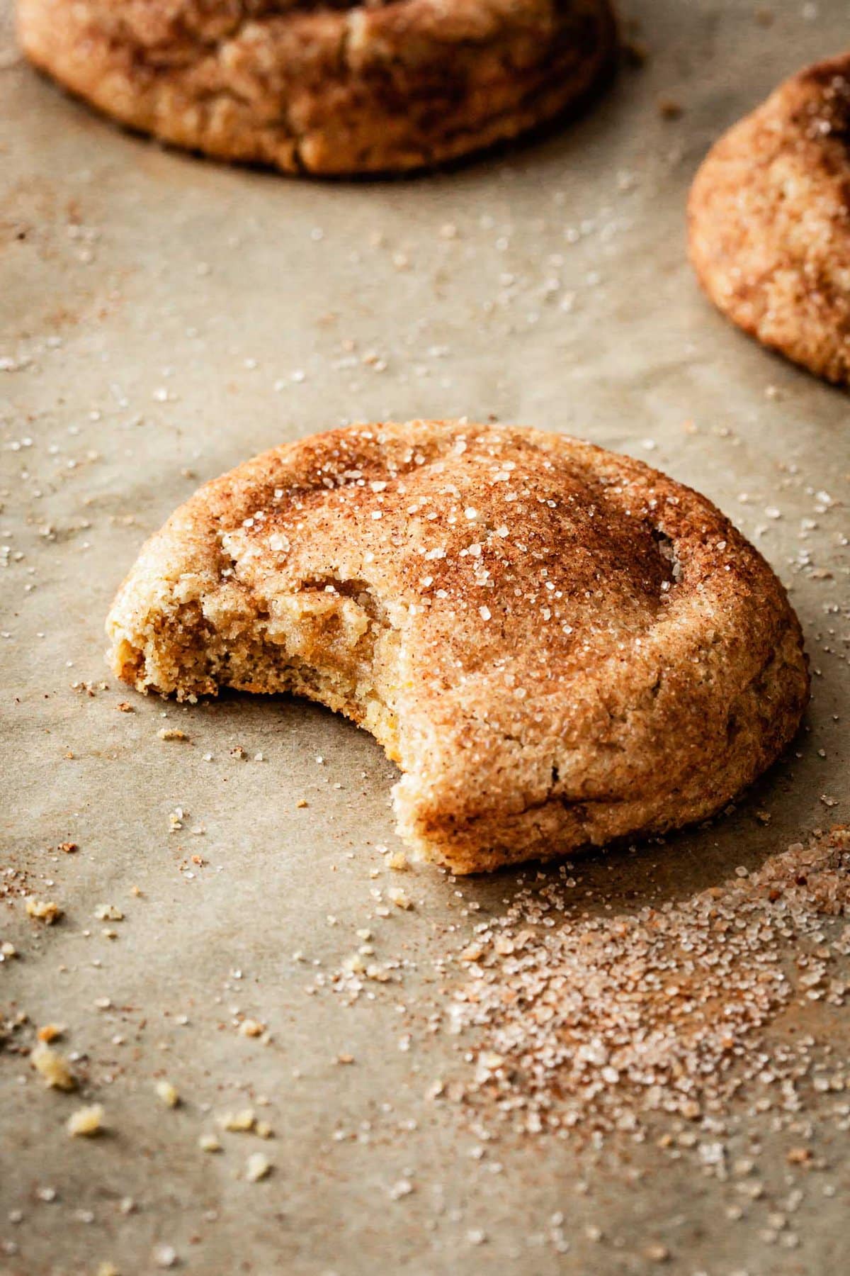 side view of a gluten-free snickerdoodle with a bite taken out revealing a gooey middle