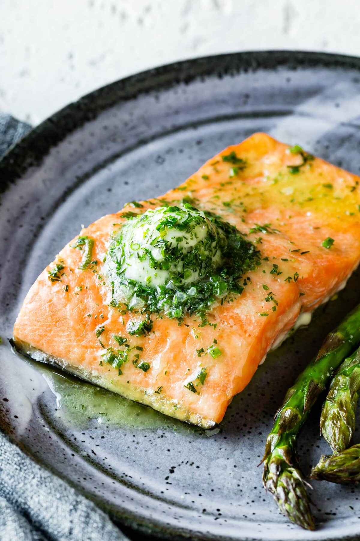 a scoop of compound butter melts over a piece of roasted salmon