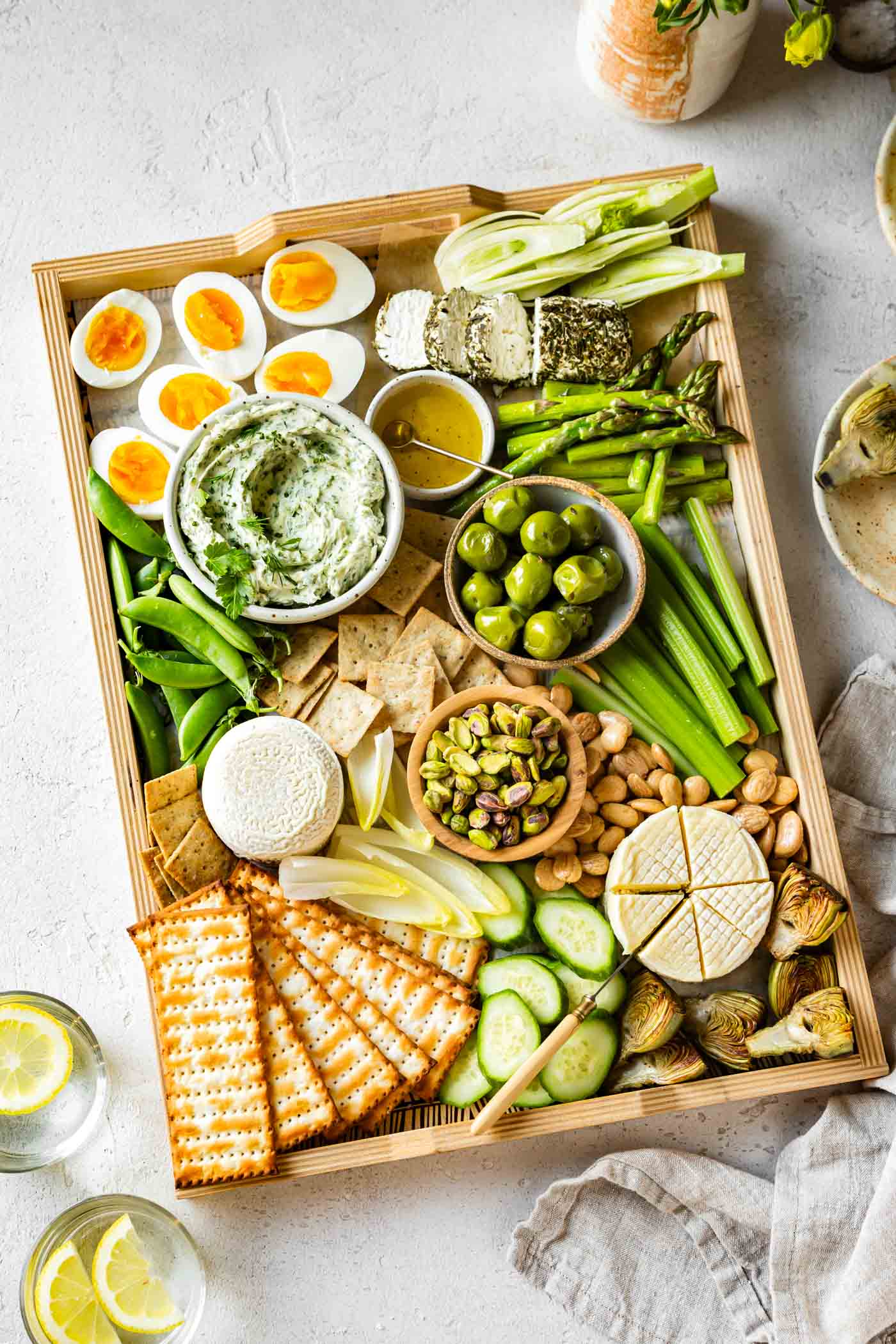 a majestic green cheeseboard features a bowl of herb compound butter