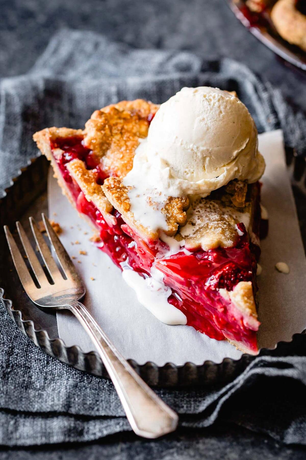 a slice of pie is topped with drippy vanilla ice cream
