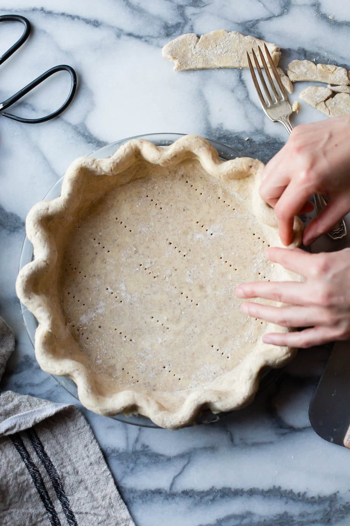 hands are shaping the bottom crust