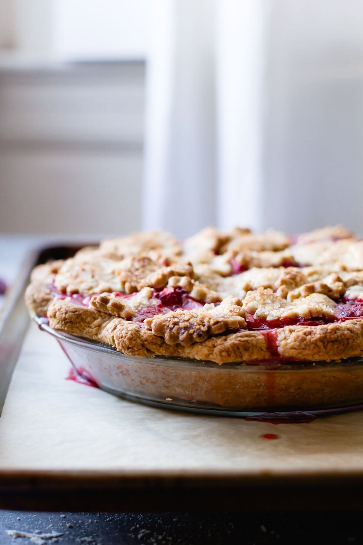 the baked pie, shown from the side with drippy fruit syrup