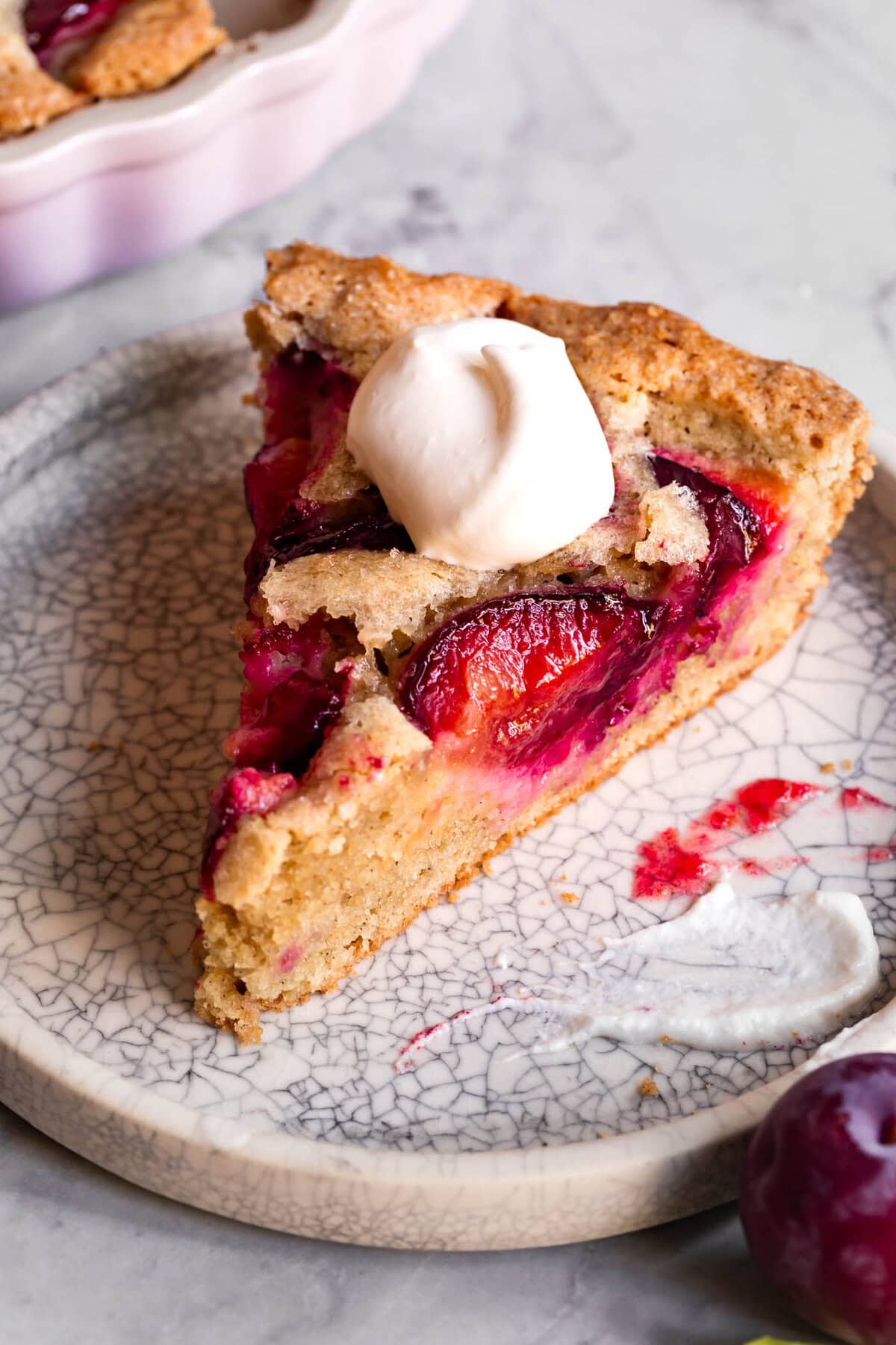 a slice of cake is on a plate topped with whipped creme fraiche